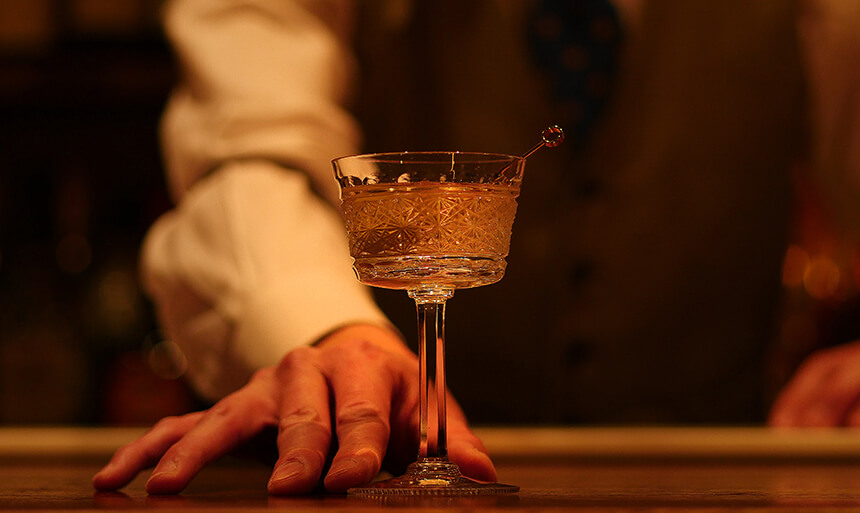 お酒を提供するバーテンダーの画像